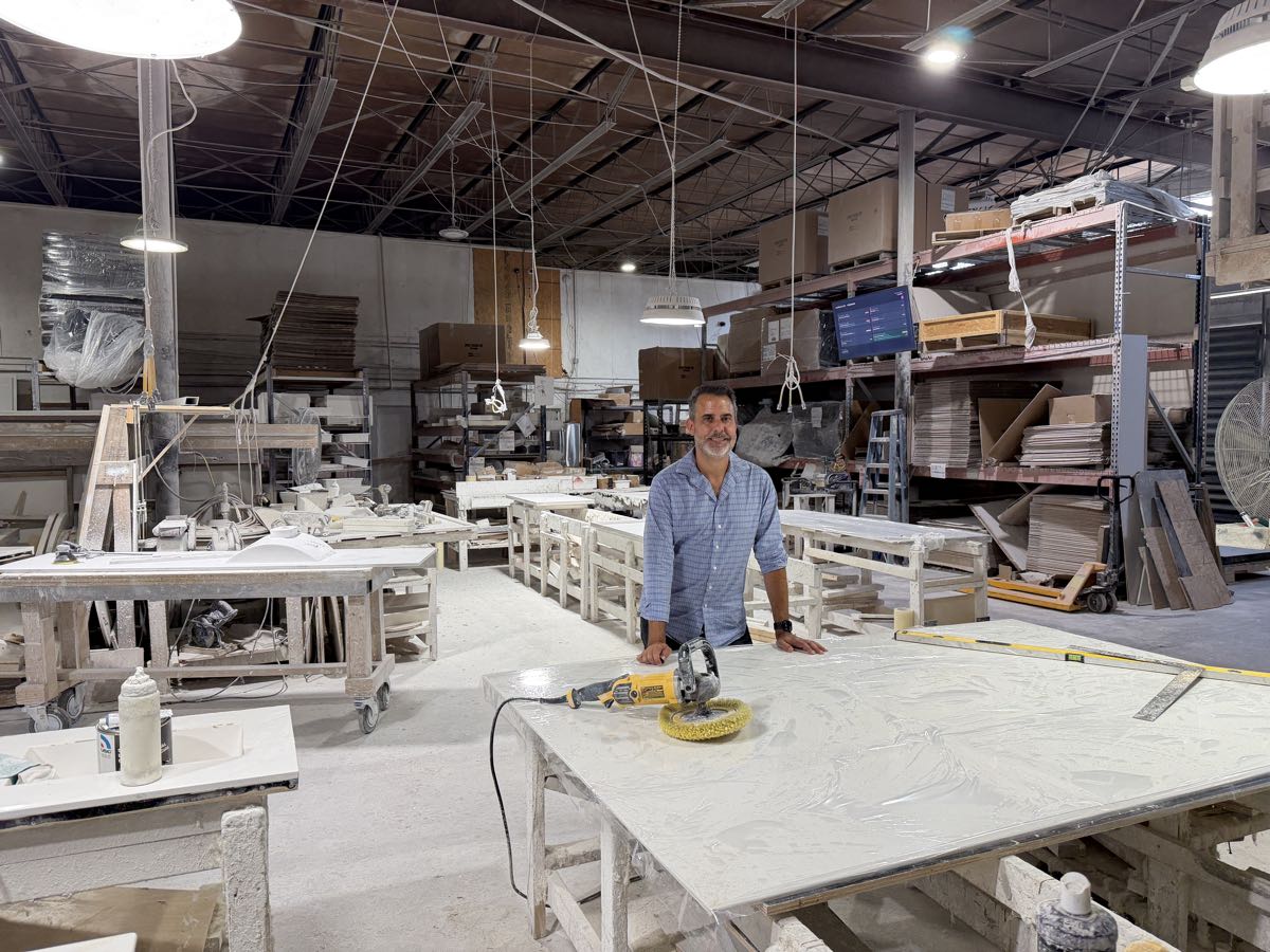 Gus Perez, owner of Marble-Lite, at a finishing table on the factory floor in Hialeah Gardens